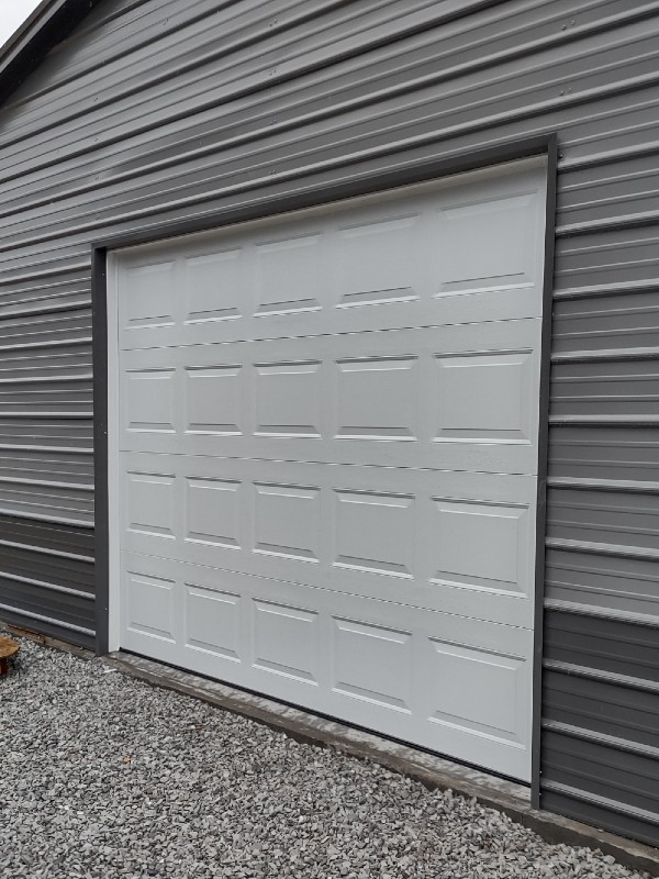 New large white garage door on metal building
